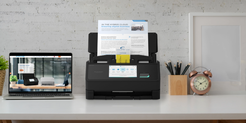 scansnap ix2500 scanner in black on a desk with different sized paper on its feeder