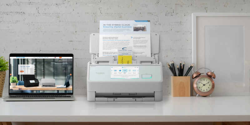 scansnap ix2500 scanner in white on a desk with different sized paper on its feeder