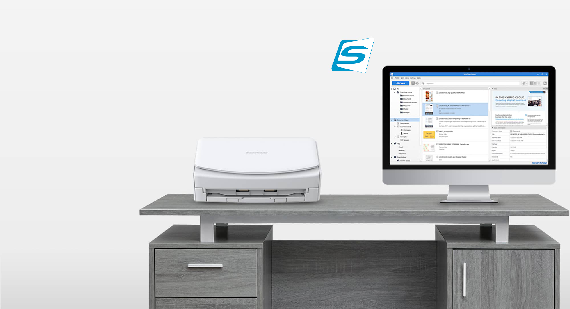 scanner ScanSnap blanc sur un bureau à côté d’un écran d’ordinateur
